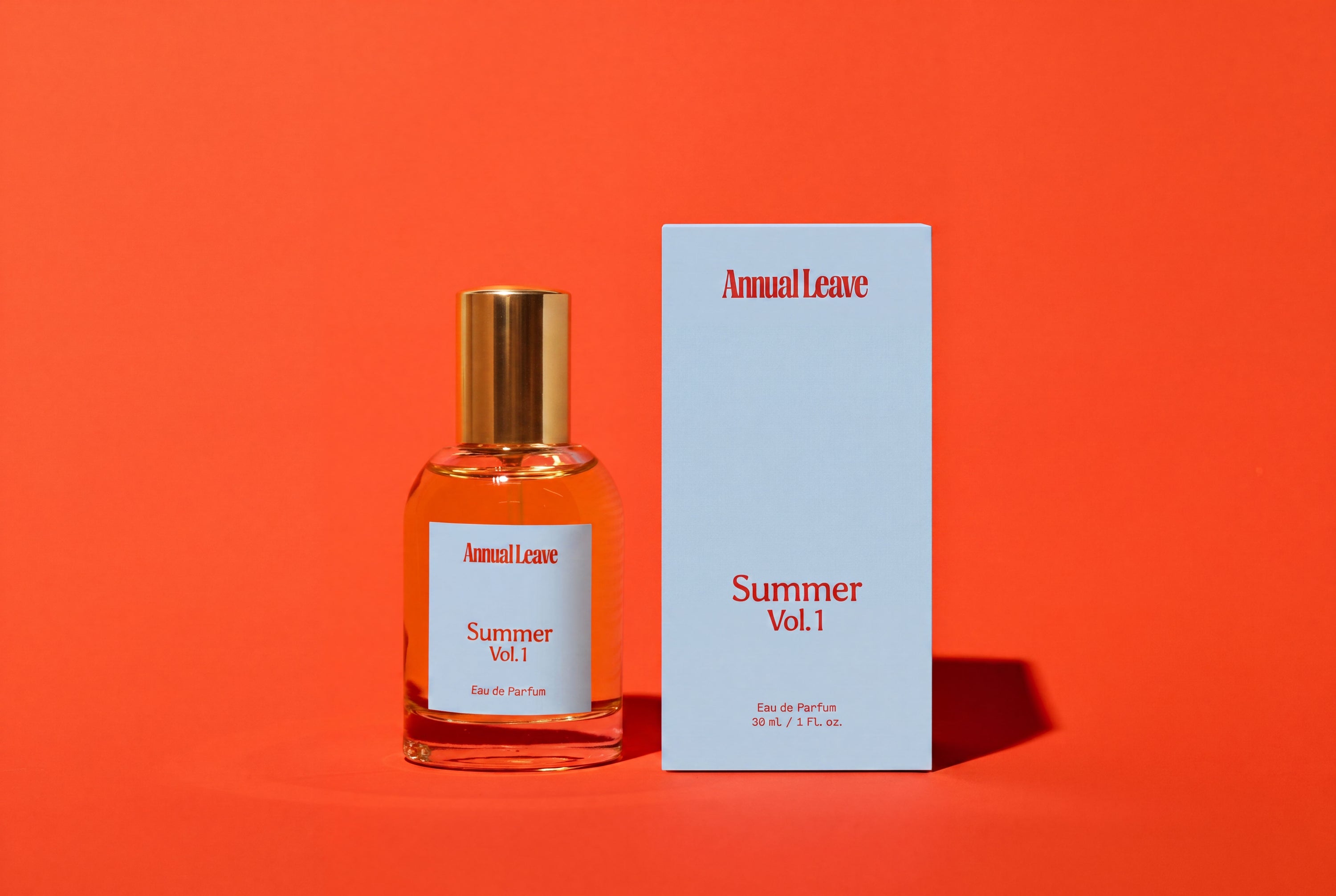 Annual Leave Summer Vol.1 Eau de Parfum bottle with a gold cap next to its light blue packaging box, set against a solid orange background.